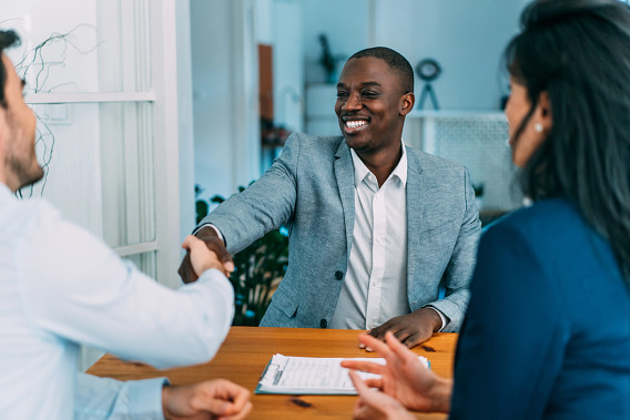 men sharing hands over desk