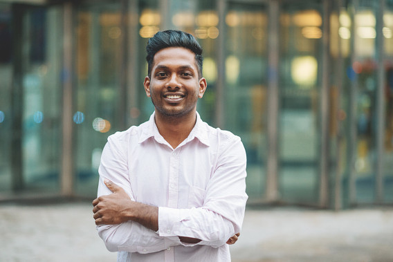 portrait of man crossing arms outside office