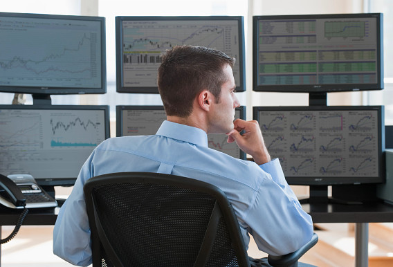 man watching finance data on six screens