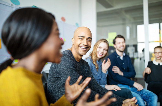 woman speaking with group of office workers