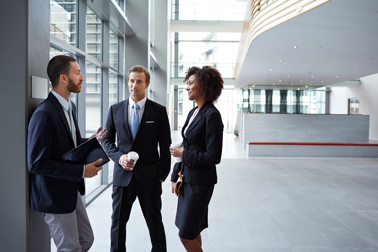 three business people casually standing and talking