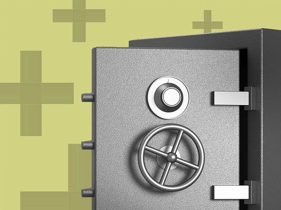 Close-up of a heavy metal safe with a circular combination dial and wheel handle on the door, shown against a light green background with abstract plus-shaped patterns.