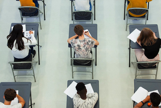 High school students taking exam at desks